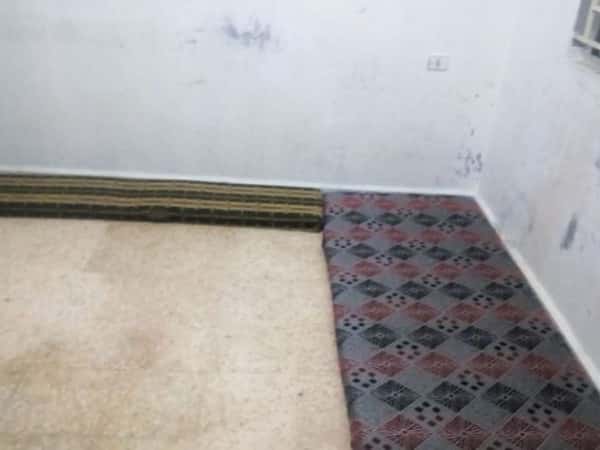 A family living in a room without furniture