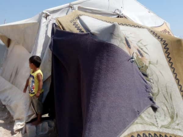 A widow and her kids have no support and live in a small tent.
