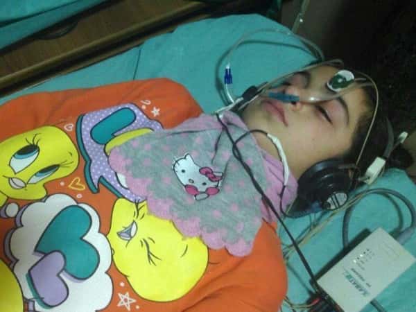 A little girl, needs hearing aid.