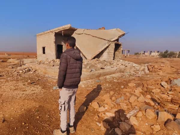 A tent atop a shattered home.