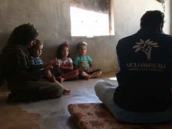 Eine Mutter und ihre Kinder leben unter schlechten humanitären Bedingungen ohne Ernährer