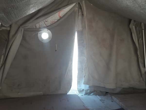 A newborn suffers in a tent