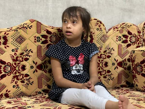 A young girl suffering from Down syndrome and multiple other illnesses